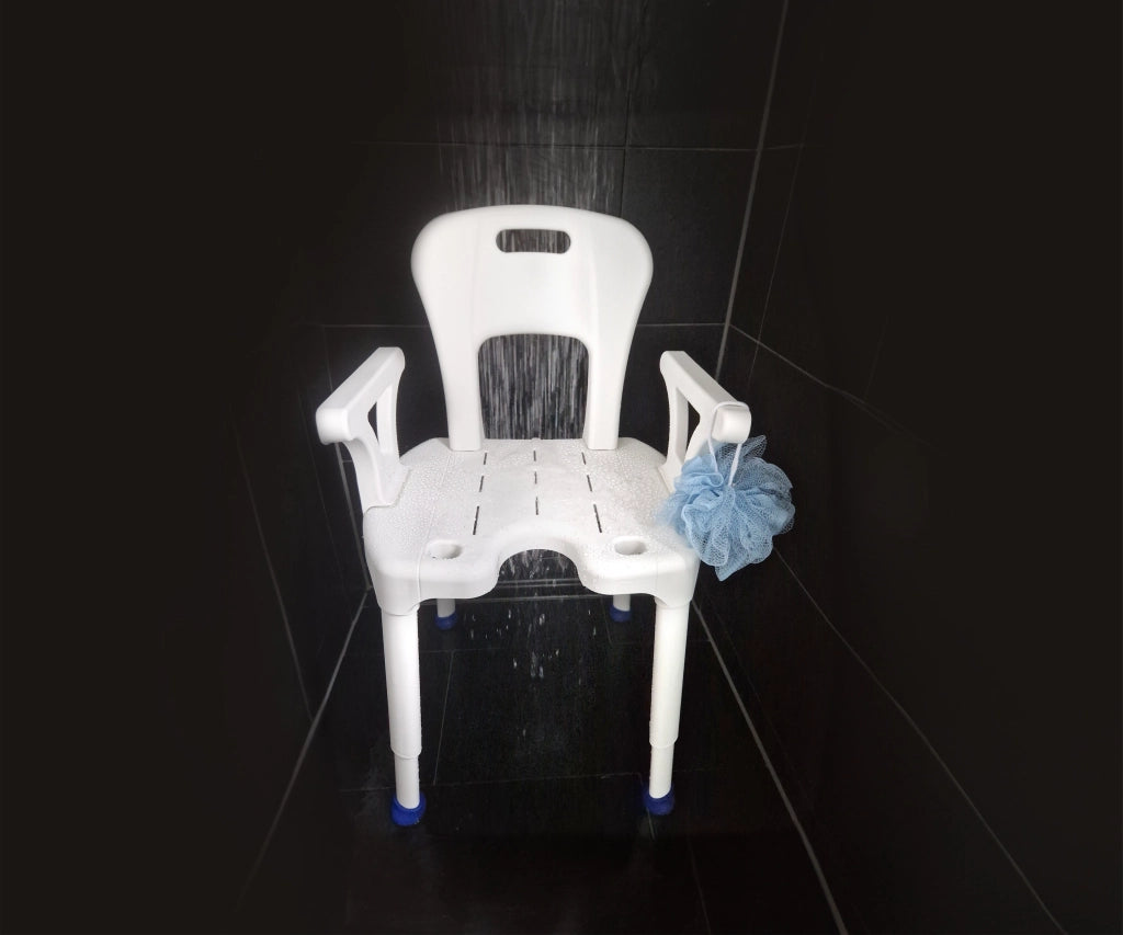 Duschstuhl AiO von Drive Medical in Anwendung – unter fließendem Wasser in einer schwarzen Dusche, mit blauer Duschblume auf der Armlehne