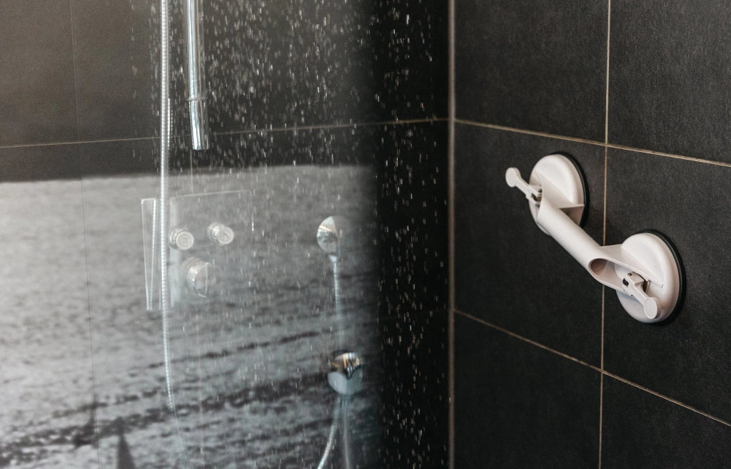 Mobiler Haltegriff Solido von Drive Medical montiert in einer modernen Dusche auf dunklen Fliesen – zeigt sichere Anwendung bei Nässe.