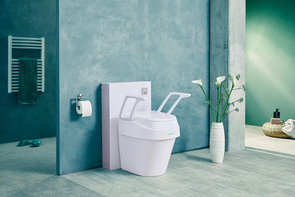 Toilettensitzerhöhung SmartFix B-Protect von Dietz auf einer modernen Toilette montiert, mit hochgeklapptem Deckel und seitlichen Armlehnen – stilvolles Badezimmerambiente mit Pflanzendekoration.