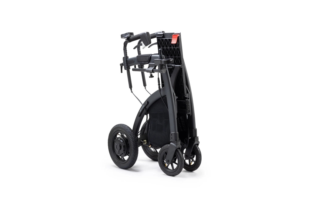 Zusammengeklappter Rollz Motion Electric in aufrechter Position. Der faltbare 3-in-1-Rollator und Elektrorollstuhl lässt sich platzsparend verstauen und einfach transportieren.