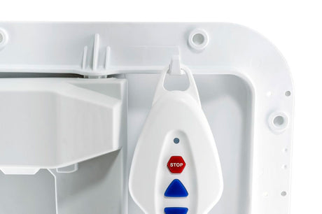 Nahaufnahme der Handsteuerung eines Badewannenlifts, sicher in der vorgesehenen Halterung an der Rückenlehne eingehängt. Die ergonomische Steuerung verfügt über gut erkennbare blaue Bedientasten zum Heben und Senken sowie eine rote „STOP“-Taste für mehr Sicherheit. Die Aufbewahrungsöse ermöglicht eine praktische und griffbereite Platzierung. Ideal für eine einfache und sichere Bedienung des Badewannenlifters.