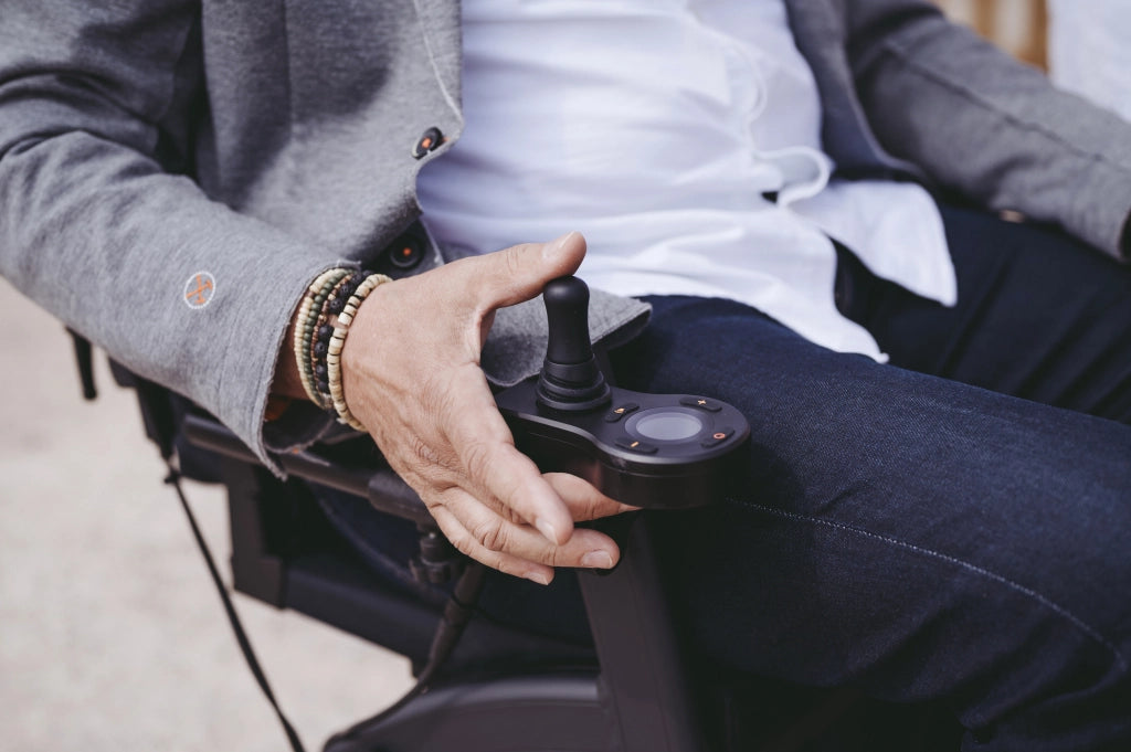 Nahaufnahme einer Hand, die den Joystick des Rollz Motion Electric bedient. Die intuitive Steuerung ermöglicht eine einfache und präzise Navigation des faltbaren Elektrorollstuhls.