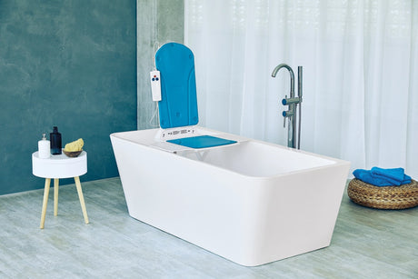 Badewannenlift mit blauer Rückenlehne und Fernbedienung in einer modernen, freistehenden Badewanne.